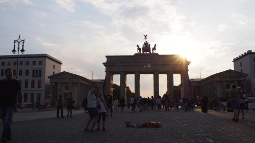 People posing in all sorts of ways around Brandenburg Gate