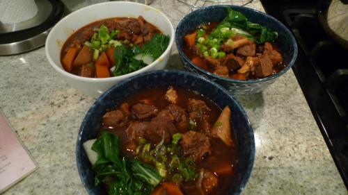 Cook fresh noodle, and place into bowl. Fill with beef, carrot/radish, and soup. Top off with bok choi and beef. Place chopped green onions on top and chinese sauerkraut to taste